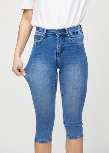 Model strækker caprisene ved låret for at vise stretch.