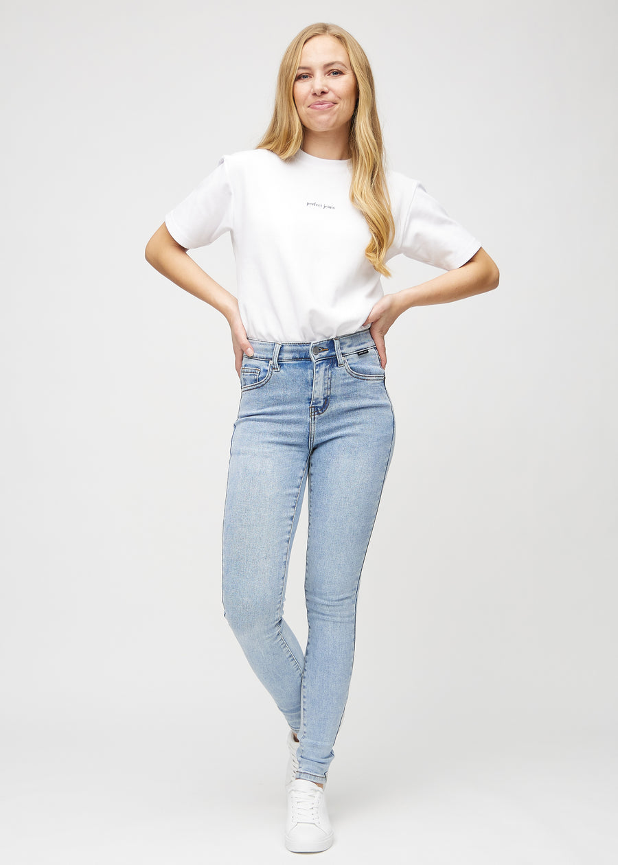 Fuldt billede af model i lys denim skinny jeans.