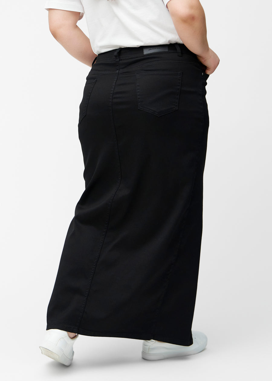 Lang, sort jeansnederdel i farven Ravens med regulær pasform set bagfra på plus-size model, så hele nederdelens længde kan ses.