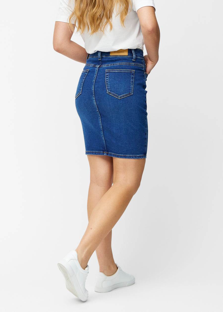 Mørkeblå, tætsiddende og knælang denimnederdel set bagfra, så hele produktet kan ses.