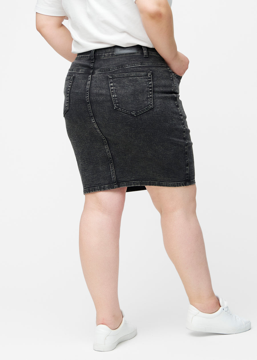 Mørkegrå, tætsiddende og knælang denimnederdel set bagfra på plus-size model, så hele produktet kan ses.