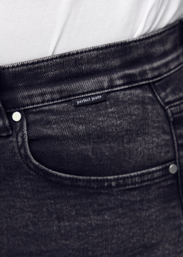 Forlommen på et par mørkegrå denim skinny short shorts, hvor man kan se logoet på en plus-size model.