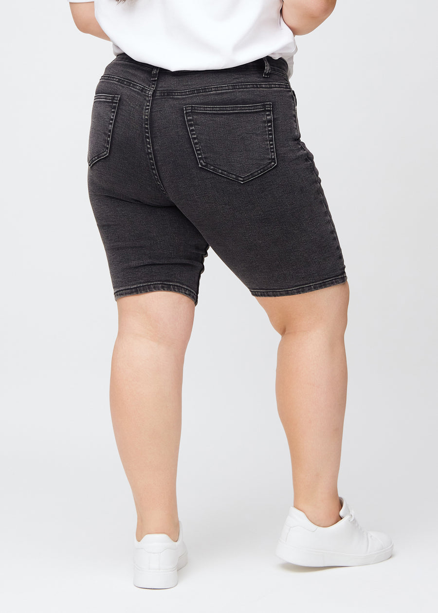 Kvinde i mørkegrå denim shorts set bagfra