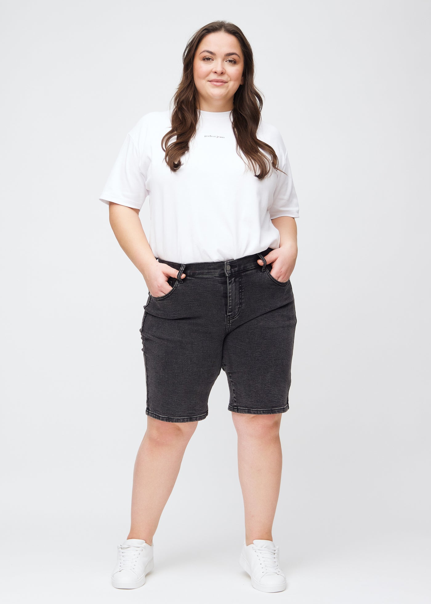 Fuldt billede af en plus-size model i mørkegrå denim regular middle shorts.