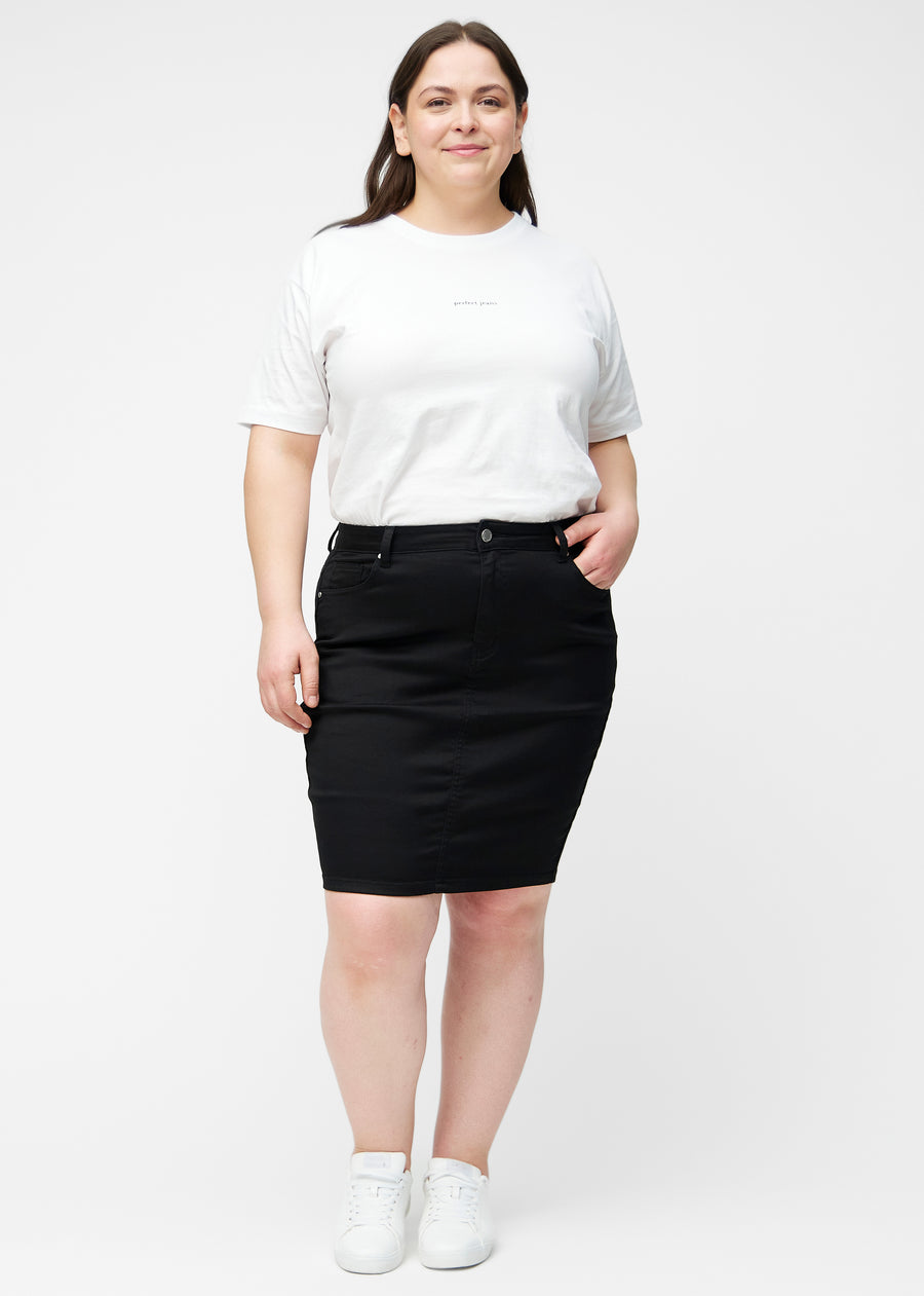 Plus-size model viser sort, tætsiddende og knælang jeansnederdel i bevægelse og strækker materialet.