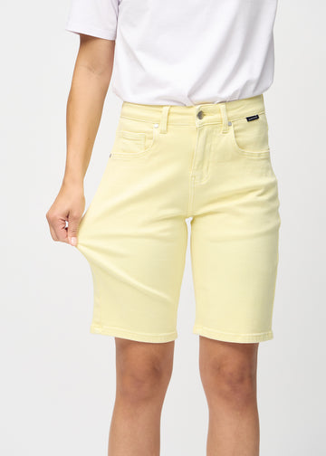 Model strækker shortsene ved låret for at vise stretch.