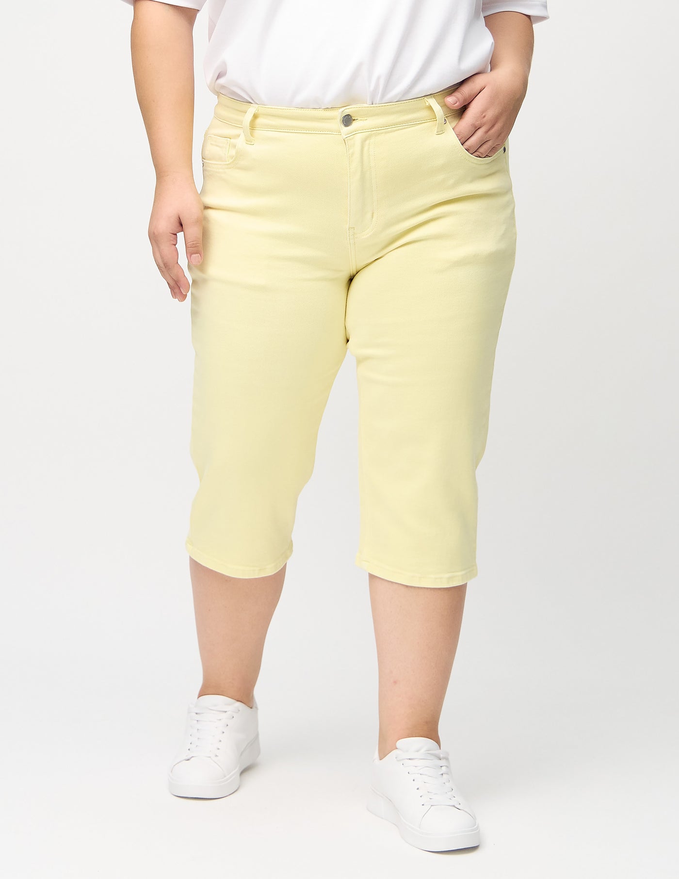 Lysegule regular capris, modelnavn Lemonades, som går lige ned langs benet på en plus-size model, set forfra.

