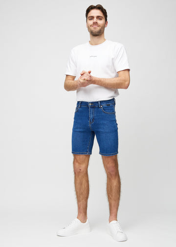 Fuldt billede af model i mørk denim regular middle shorts.