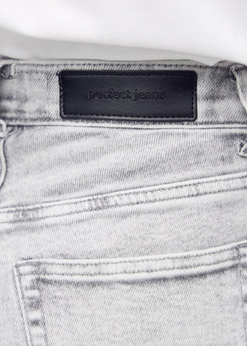 Nærbillede af lysegrå denim med Perfect Jeans læderpatch bagpå i taljen.