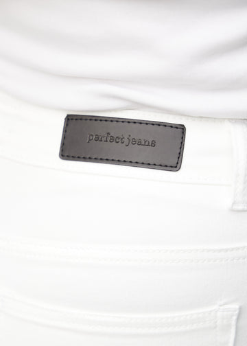Nærbillede af hvidt jeansmateriale med Perfect Jeans læderpatch bagpå i taljen, på en plus-size model.