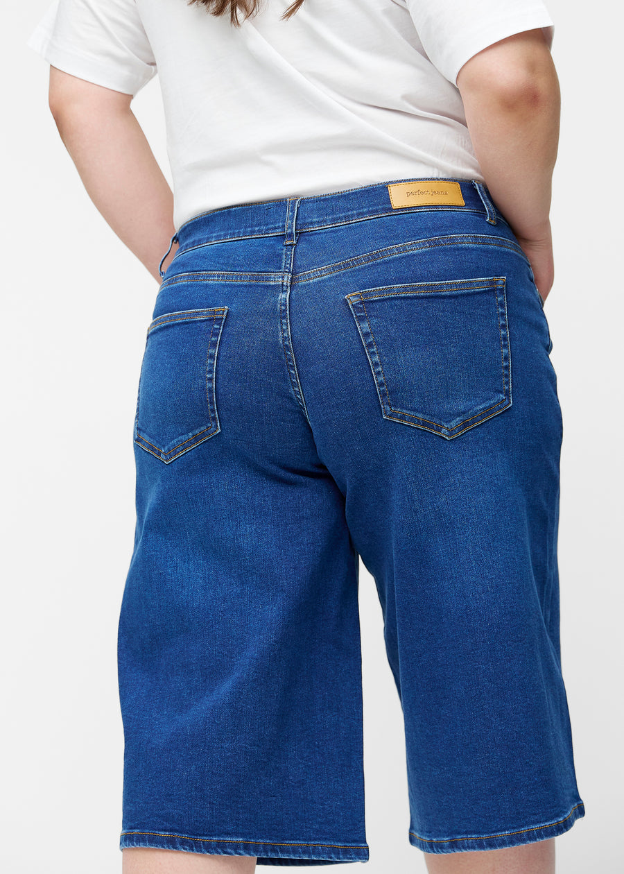 Løse, mørkeblå denim capris i farven Oceans set bagfra tæt på på plus-size model for at vise pasform og detaljer.