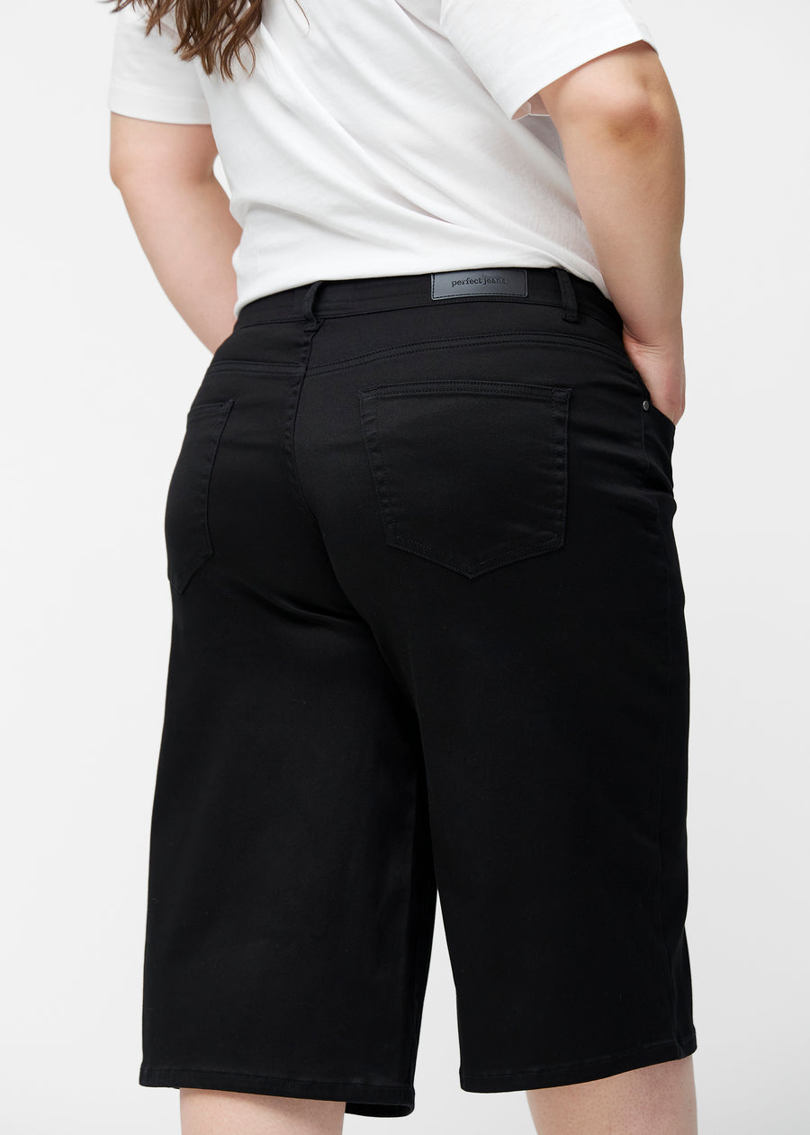 Løse, sorte capris i farven Ravens set bagfra tæt på på plus-size model for at vise pasform og detaljer.