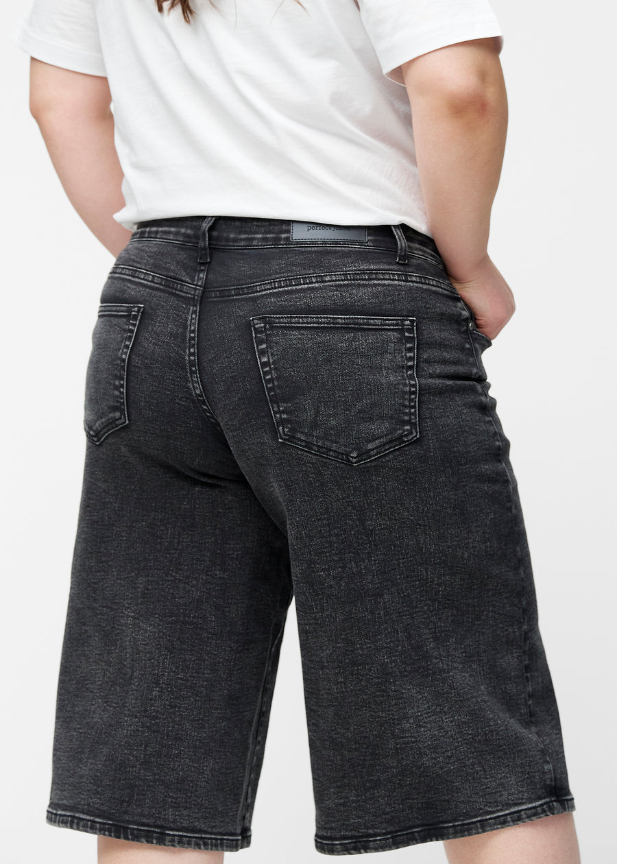 Løse, mørkegrå denim capris i farven Shadows set bagfra tæt på på plus-size model for at vise pasform og detaljer.