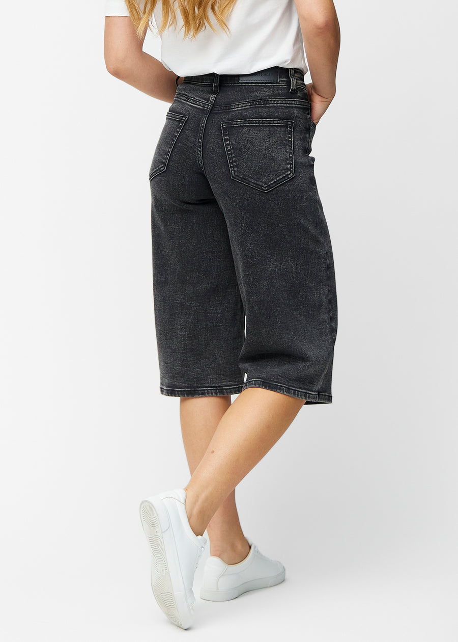 Løse, mørkegrå denim capris i farven Shadows set bagfra, så pasform og længde kan ses.