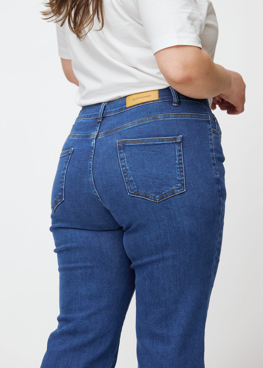 Dunkelblaue Mid-Rise-Bootcut-Jeans in der Farbe Oceans. Nahaufnahme der Rückseite an einem Plus-Size-Model, um Details zu zeigen.