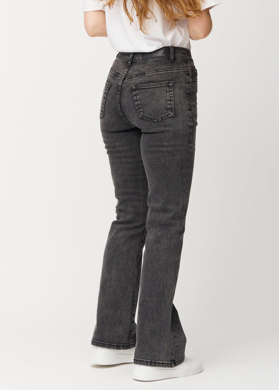 Dunkelgraue Mid-Rise-Bootcut-Jeans in der Farbe Shadows. Rückansicht an einem Model, die gesamte Passform ist zu sehen.
