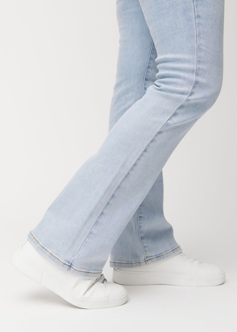 Hellblaue Mid-Rise-Bootcut-Jeans in der Farbe Waves. Nahaufnahme am Knöchel eines Model, um den leichten Schlag am Beinabschluss zu zeigen.
