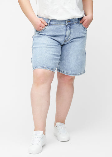 Lockere, hellblaue Denim-Shorts in der Farbe Waves von vorne am Plus-Size-Model, die an der Hüfte sitzen und locker fallen.