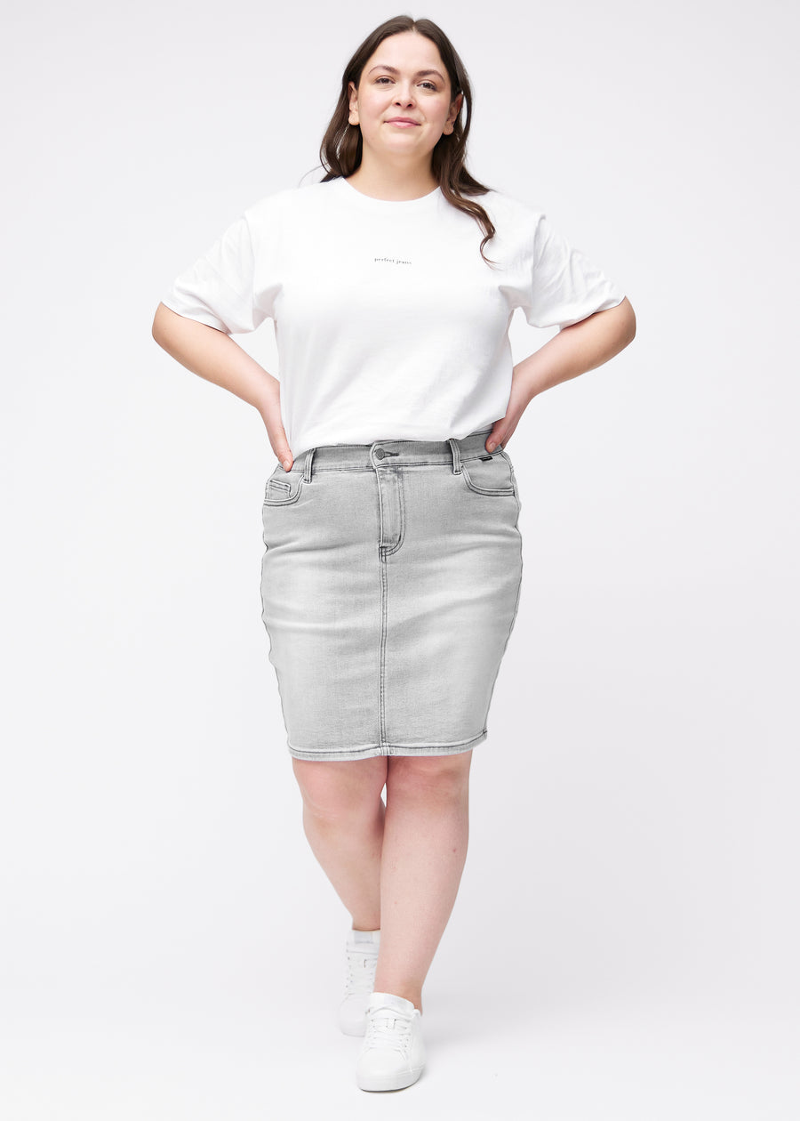 Fuldt billede af plus-size model i lysegrå, tætsiddende og knælang denimnederdel.