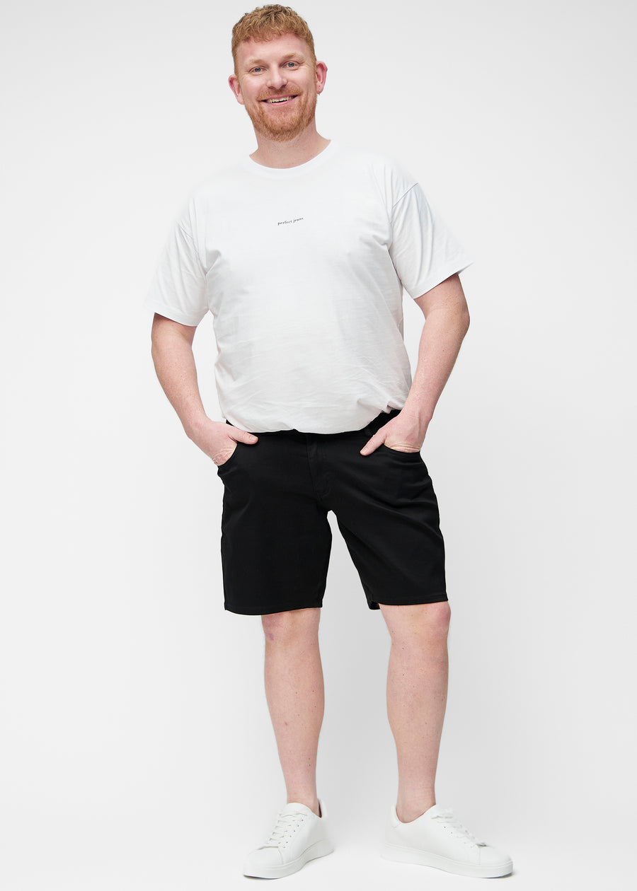 Ganzkörperbild eines Plus-Size-Modells in schwarzen Shorts für Herren in der Farbe Ravens mit Regular-Passform.
