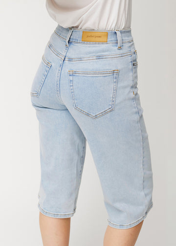 Nahaufnahme von hinten: lockere, hellblaue Waves Denim-Capris, die Passform und Details zeigen.
