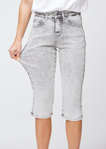 Das Model zieht die Capris am Oberschenkel auseinander, um den Stretch zu zeigen.