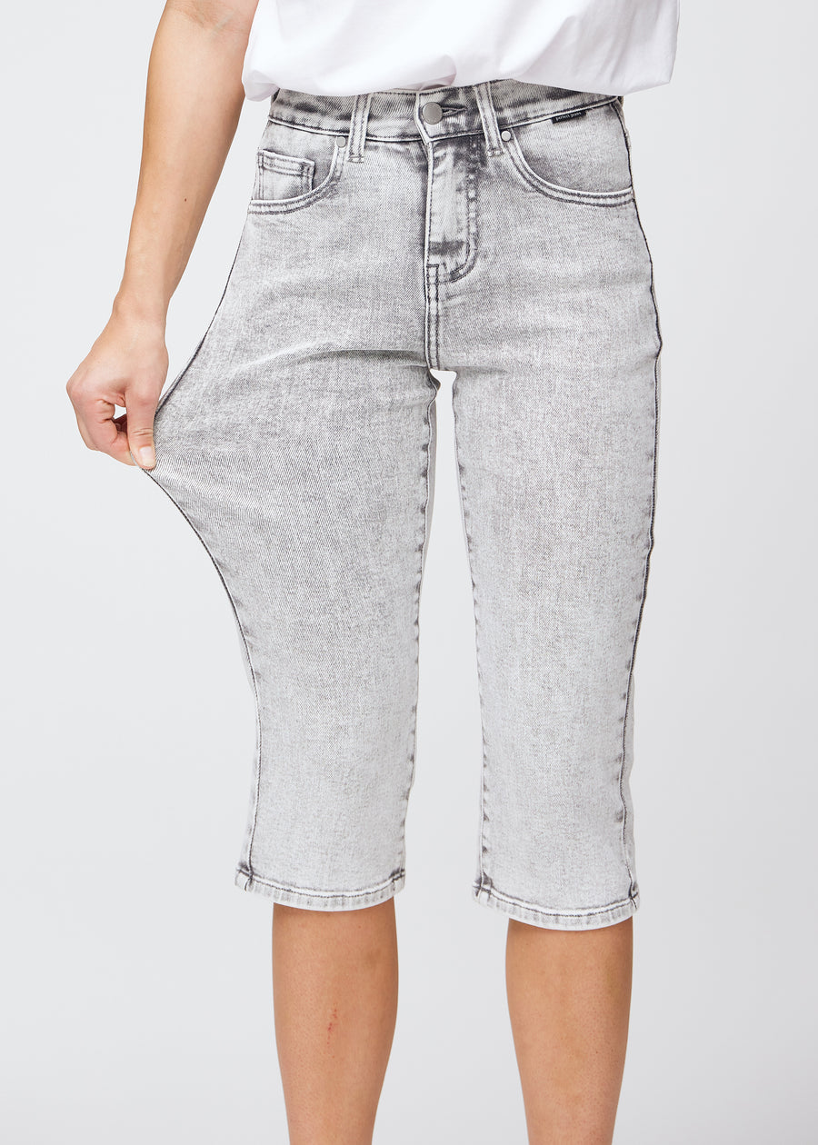 Das Model zieht die Capris am Oberschenkel auseinander, um den Stretch zu zeigen.