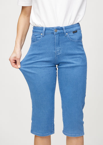 Das Model zieht die Capris am Oberschenkel auseinander, um den Stretch zu zeigen.
