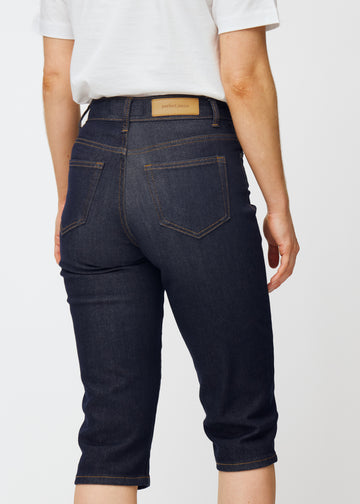 Tief dunkelblaue Denim-Capris für Damen in der Farbe Midnights von hinten nah aufgenommen, um Passform und Details zu zeigen.