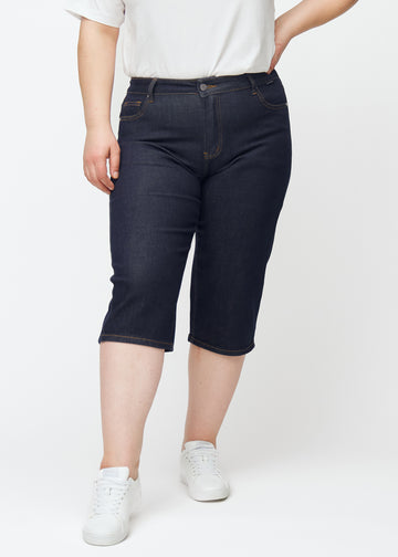 Tief dunkelblaue Denim-Capris für Damen in der Farbe Midnights mit Regular-Passform, von vorne auf einem Plus-Size-Model gesehen.