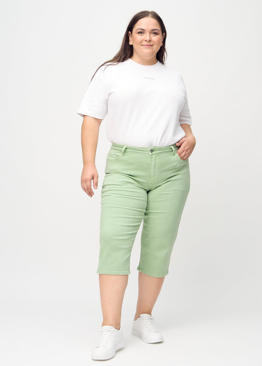 Ganzkörperbild eines Plus-Size-Models in hellgrünen regular Capris.