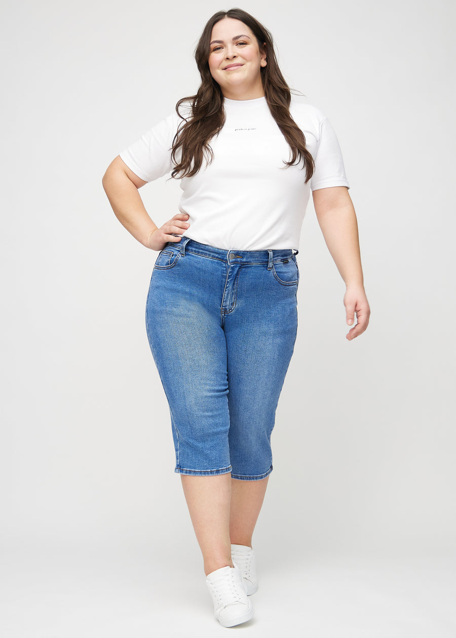 Ganzkörperbild eines Plus-Size-Models in Denim-regular-Capris.
