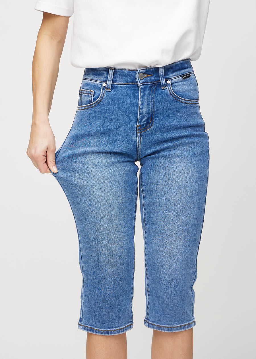 Das Model zieht die Capris am Oberschenkel auseinander, um den Stretch zu zeigen.