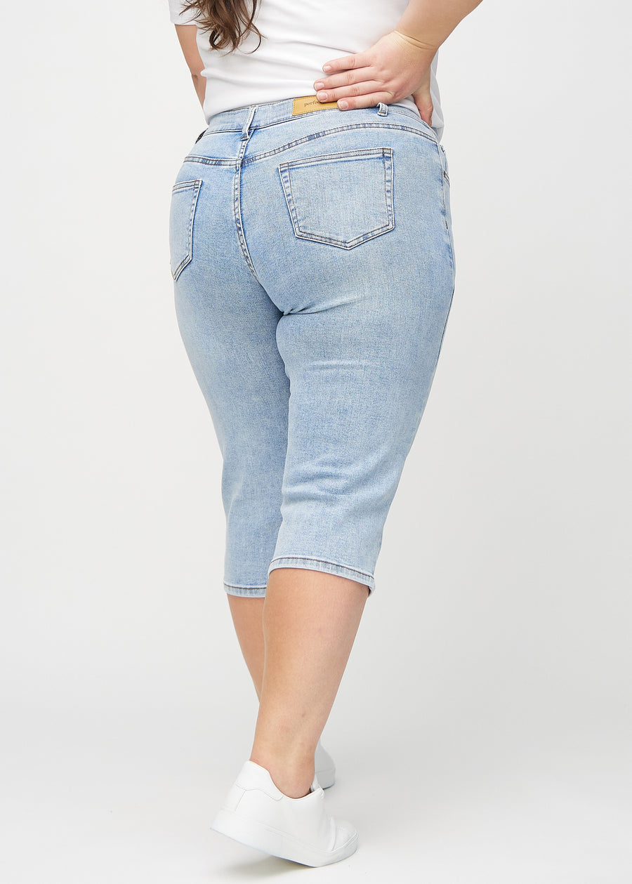 Hellblaue Denim-regular-Capris an einem Plus-Size-Model von hinten gesehen, sodass man das gesamte Produkt sehen kann.