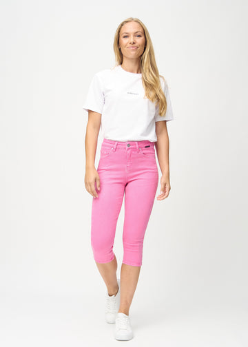 Skinny-Capris für Damen in pastellrosa Jeansstoff, Farbe Flamingos. Ganzkörperansicht eines Models in den Capris.