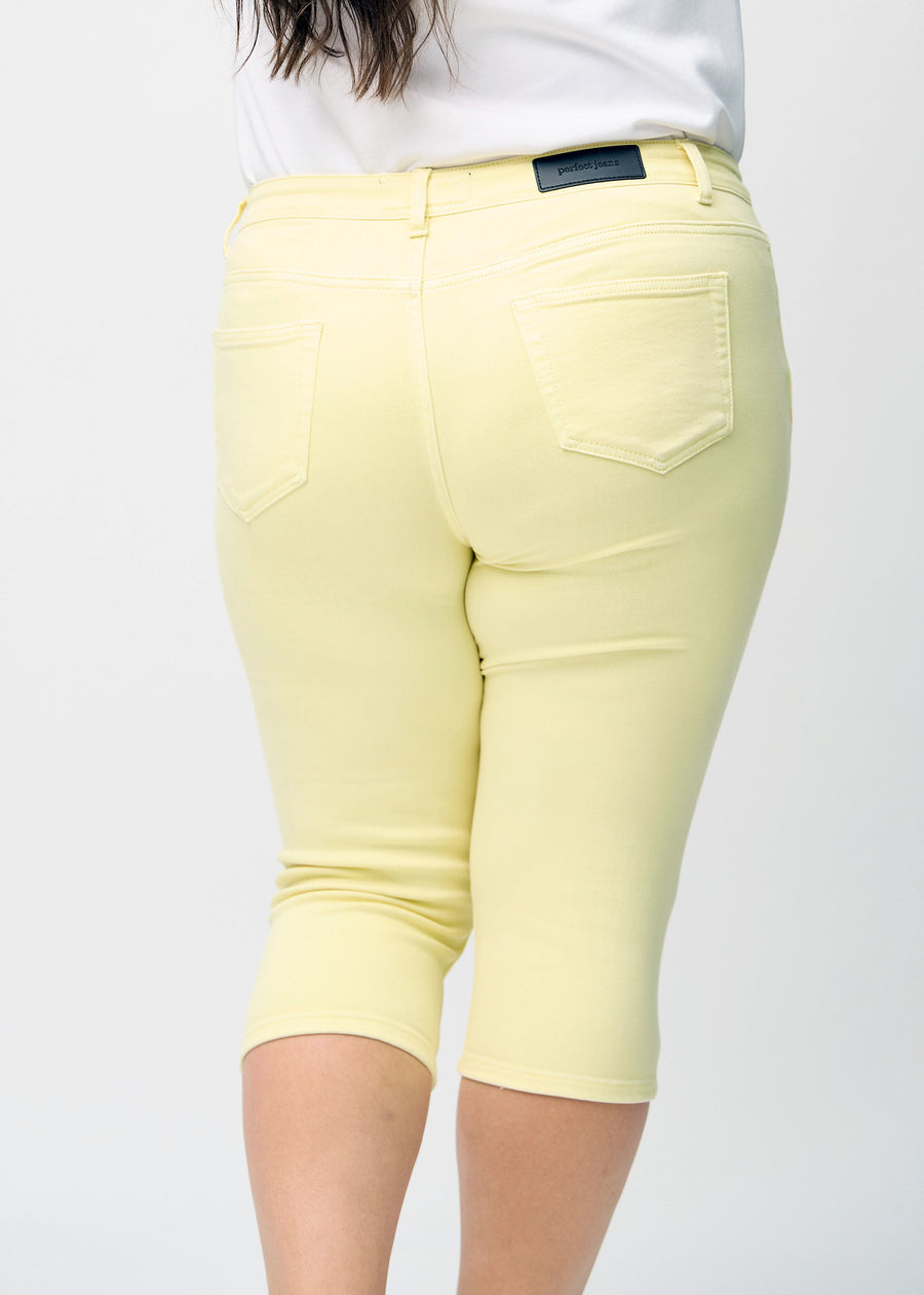  Hellgelbe skinny Capris, von hinten nah an einem Plus-Size-Model gesehen, um Details zu zeigen.