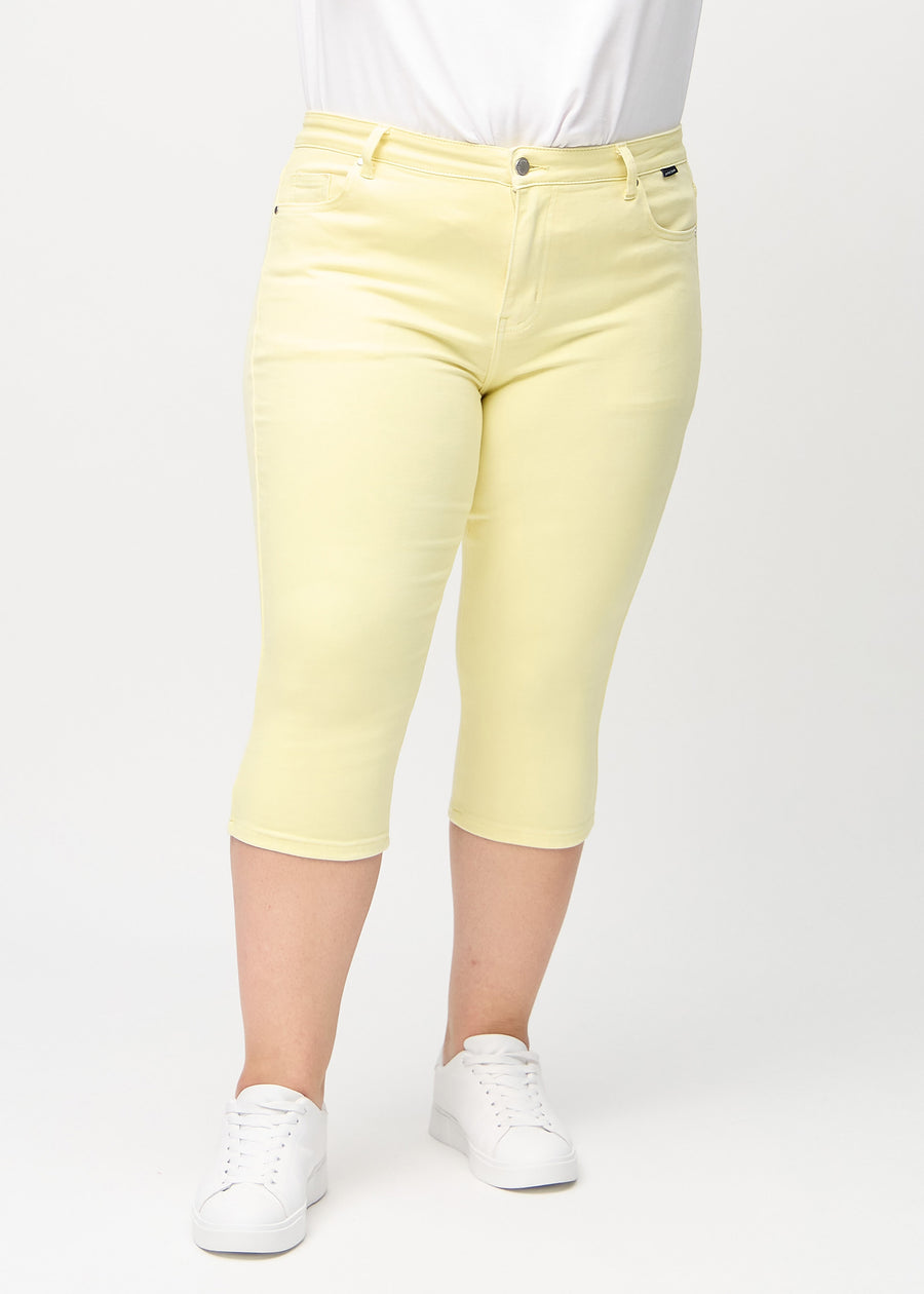 Hellgelbe skinny Capris, Modellname Lemonades, die eng am Bein anliegen, an einem Plus-Size-Model, von vorne gesehen.