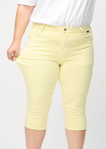 Plus-Size-Model dehnt die Capris am Oberschenkel, um den Stretch zu zeigen.