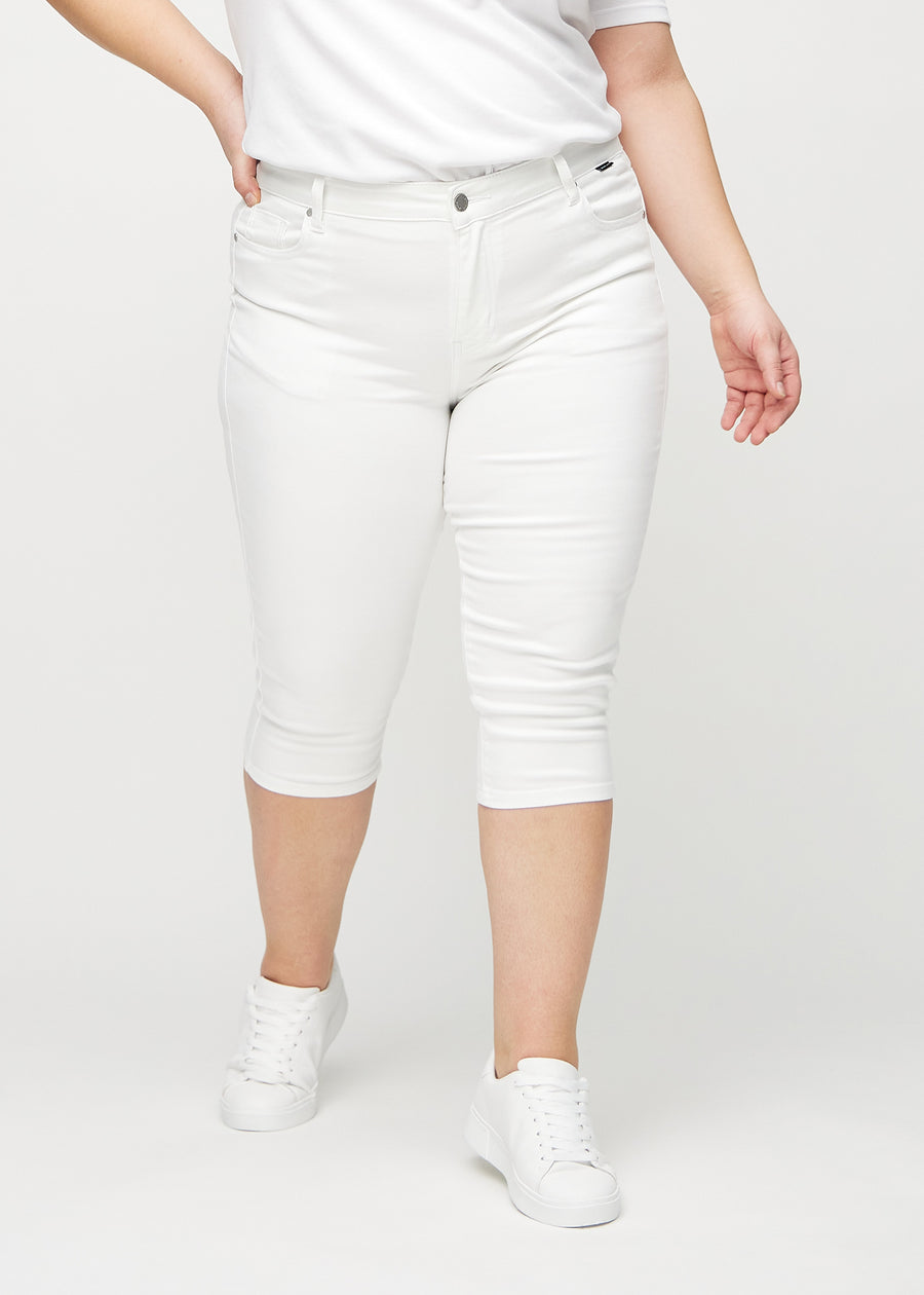 Weiße skinny Capris, Modellname Marguerites, die eng am Bein anliegen und direkt unter dem Knie an einem Plus-Size-Model enden, von vorn gesehen.
