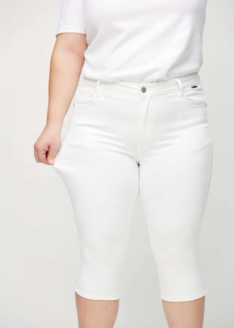 Das Plus-Size-Model zieht die Capris am Oberschenkel auseinander, um den Stretch zu zeigen.