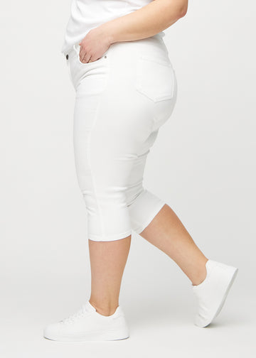 Weiße skinny Capris seitlich an einem Plus-Size-Model gezeigt.