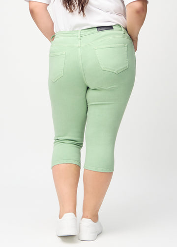 Skinny-Capris für Damen in pastellgrünem Jeansstoff, Farbe Mints. Rückansicht an einem Plus-Size-Model, zeigt die Passform und Gesäßtaschen.