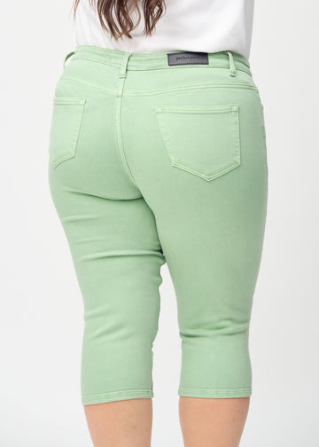 Skinny-Capris für Damen in pastellgrünem Jeansstoff, Farbe Mints. Nahaufnahme von hinten an einem Plus-Size-Model, zeigt Taschen und Nähte.