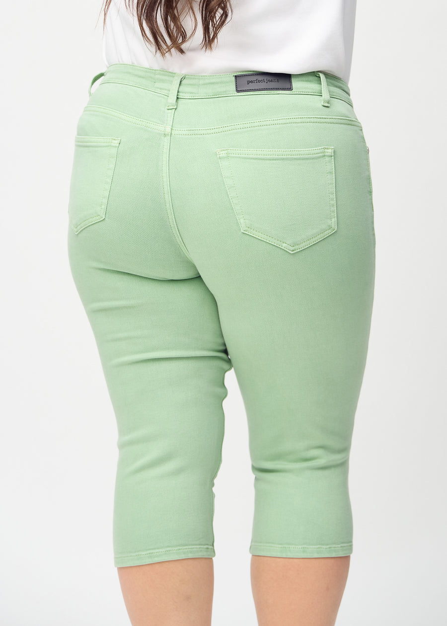 Skinny-Capris für Damen in pastellgrünem Jeansstoff, Farbe Mints. Nahaufnahme von hinten an einem Plus-Size-Model, zeigt Taschen und Nähte.