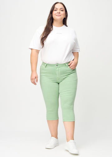 Skinny-Capris für Damen in pastellgrünem Jeansstoff, Farbe Mints. Ganzkörperansicht eines Plus-Size-Models in den Capris.