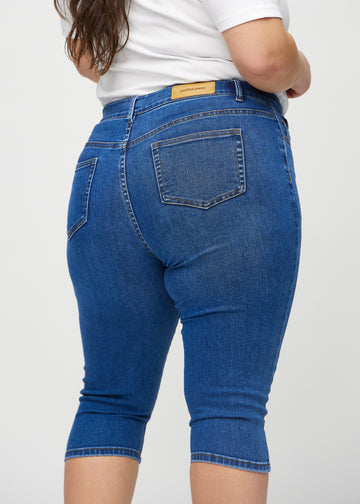Skinny-Capris für Damen in dunkelblauem Denim, Farbe Oceans. Nahaufnahme von hinten an einem Plus-Size-Model, zeigt Taschen und Nähte.