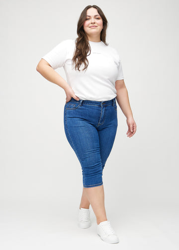 Skinny-Capris für Damen in dunkelblauem Denim, Farbe Oceans. Ganzkörperansicht eines Plus-Size-Models in den Capris.