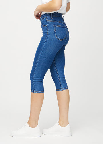 Skinny-Capris für Damen in dunkelblauem Denim, Farbe Oceans. Seitenansicht an einem Model, die figurbetonte Passform ist zu sehen.