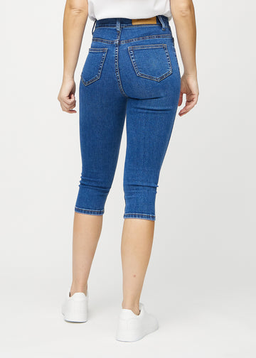 Skinny-Capris für Damen in dunkelblauem Denim, Farbe Oceans. Rückansicht an einem Model, zeigt die Passform und Gesäßtaschen.