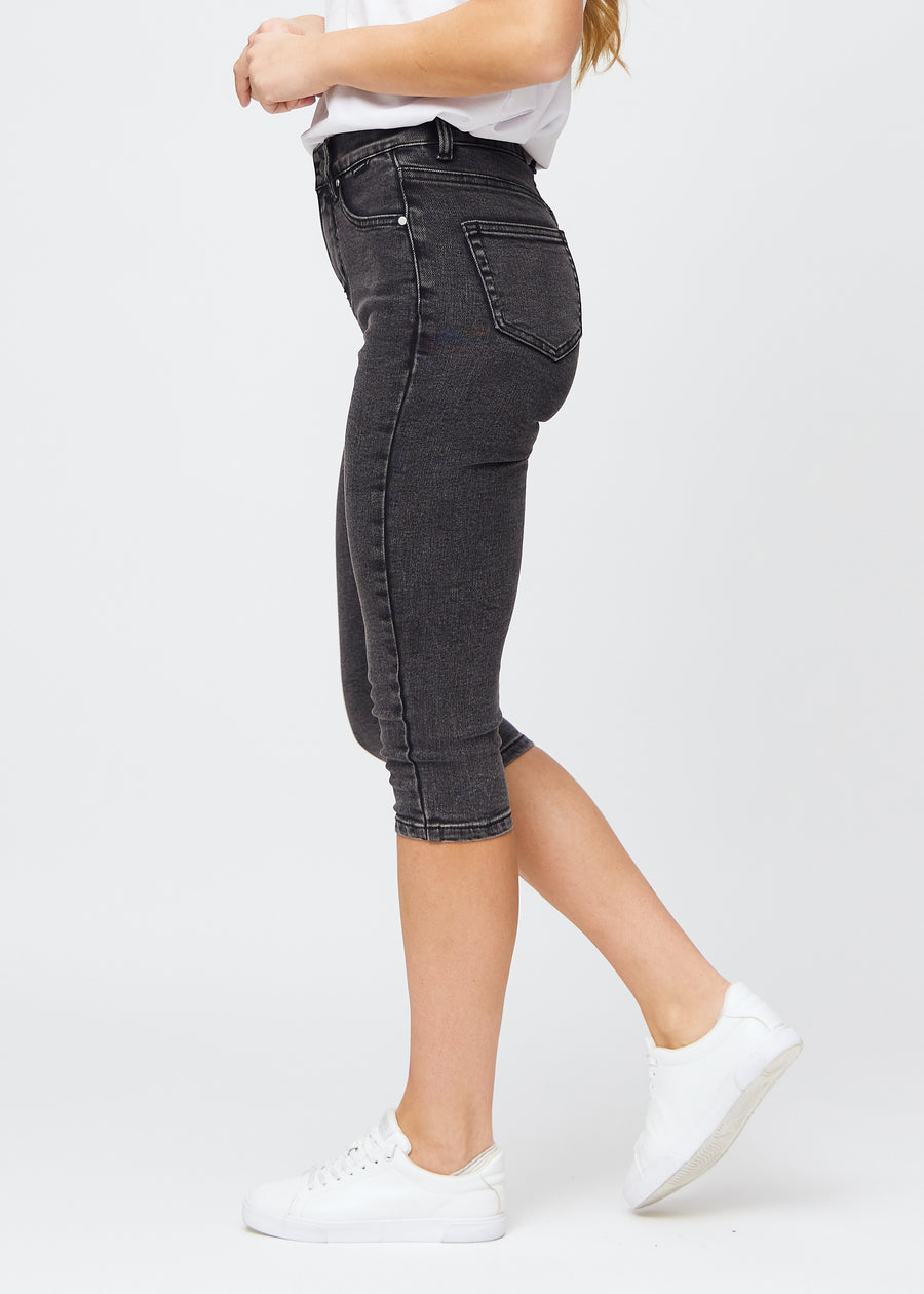 Frau in dunkelgrauen Shadows Denim-Capris im Skinny Fit, von der Seite gesehen.